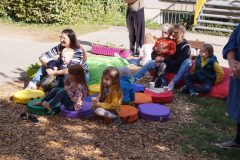 Gruppe Kinder und Eltern auf farbenfrohen Sitzkissen