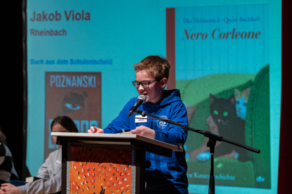 SJG-Schulsieger Jakob liest am Rednerpult aus dem Buch Nero Corleone