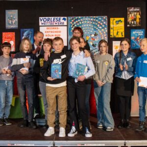 Charlotte aus Rheinbach und Alexander stehen in der Gruppe mit allen TeilnehmerInnen auf der Bühne.