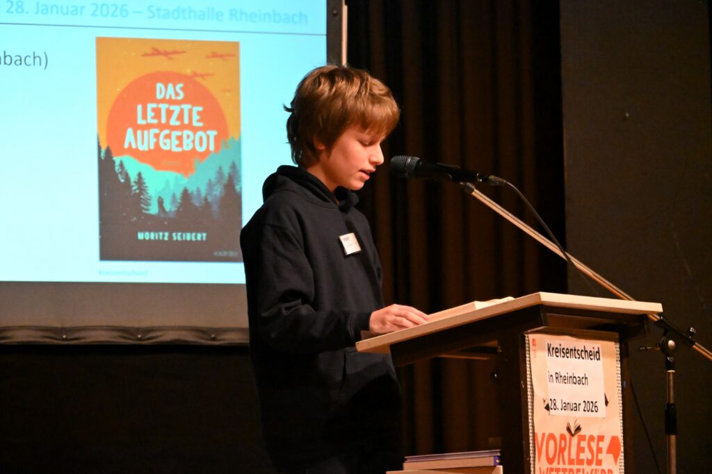 Der neue Kreissieger Jonathan Fronhoffs steht am Lesepult auf der Bühne