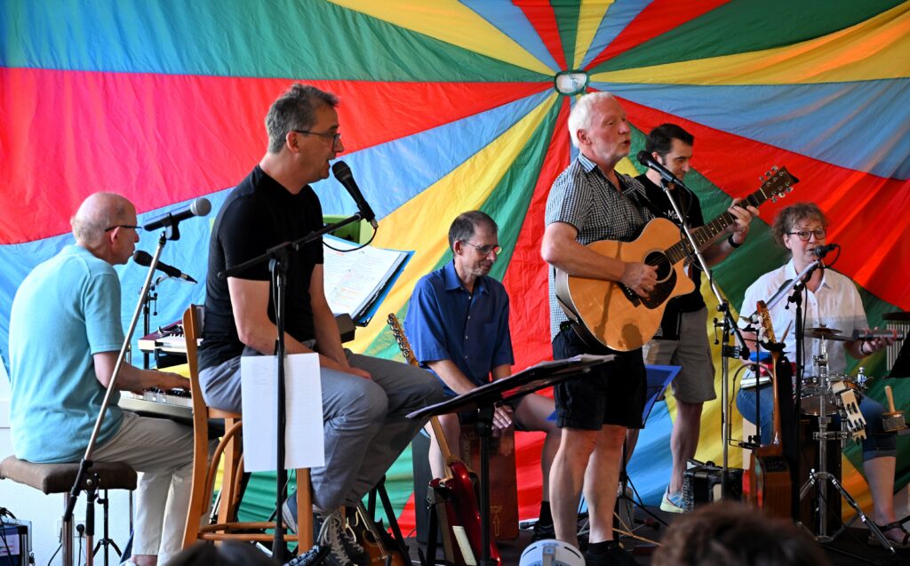 Gerd Engel singt sitzend am Mikrophon.