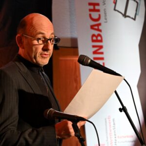 Lothar Tolksdorf steht am Mikrofon und liest vor